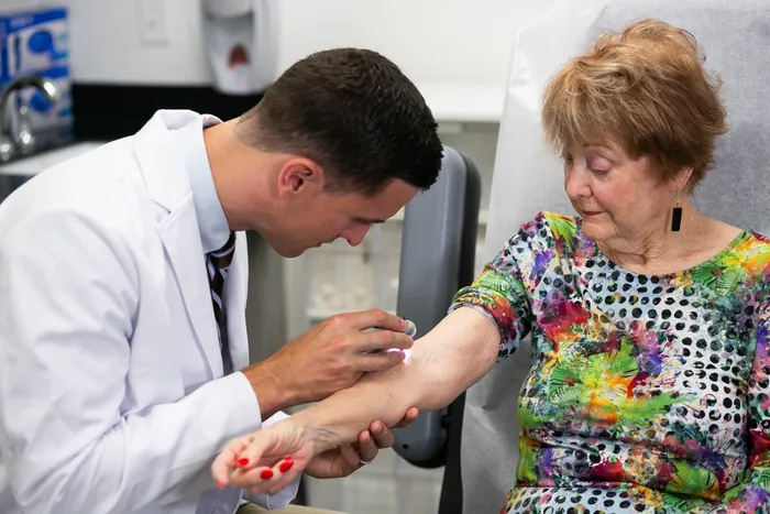 Dr. Hudson explaining examining a patients skin